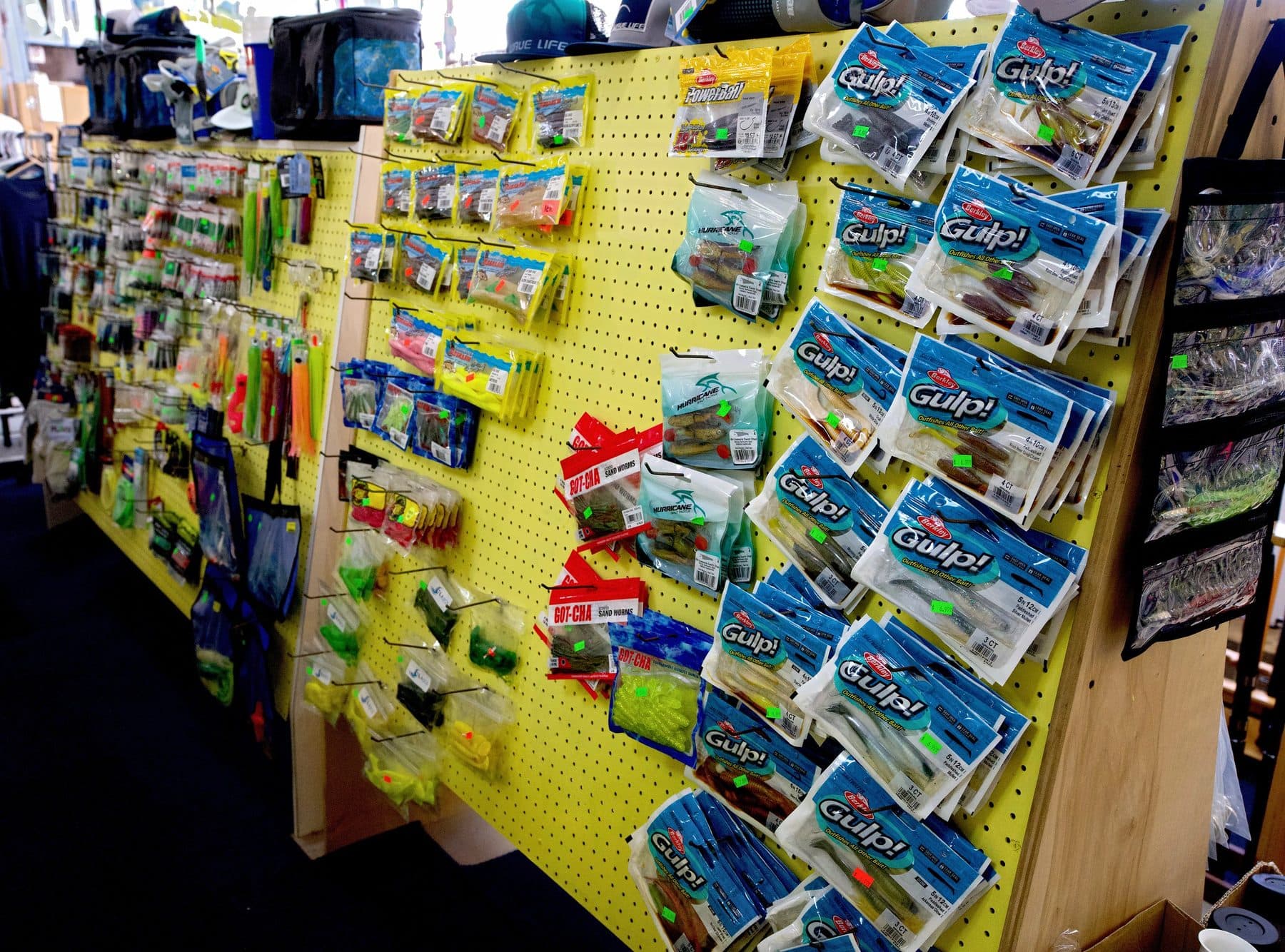 Angled pegboard endcap full of Berkley Gulp! soft plastic bags, Hurricane swim shads and Got-Cha sand worms