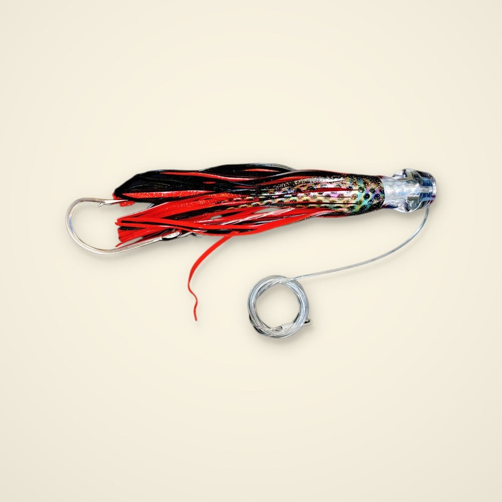 Rigged trolling skirt lure with a clear head, red and black skirt over a spotted holographic insert, hook and leader coil