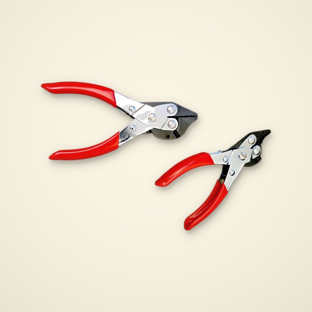 Two red-handled parallel action wire cutters with chrome bodies and black jaws on a light background